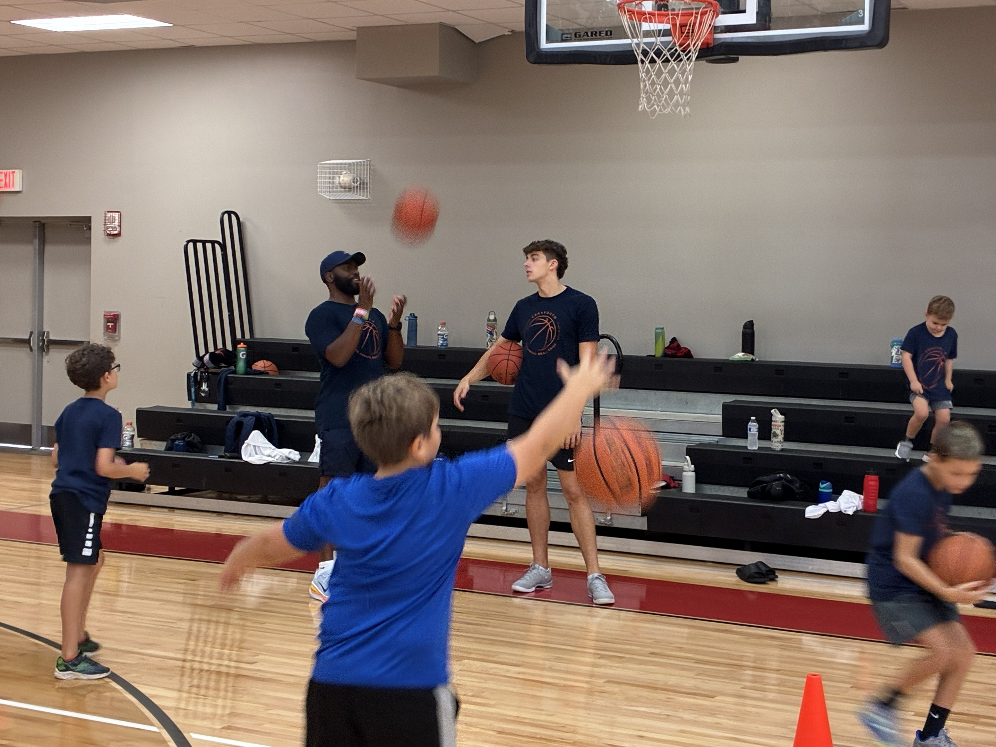 Coach leading basketball drills with CBA4Youth campers